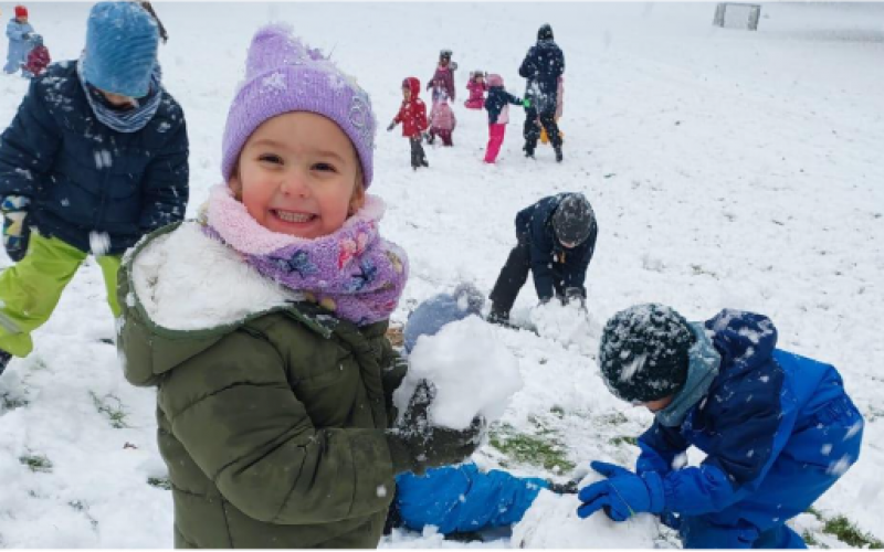 Kinder spielen gemeinsam im Schnee als Bild für Resilienz und Alltagserfahrungen